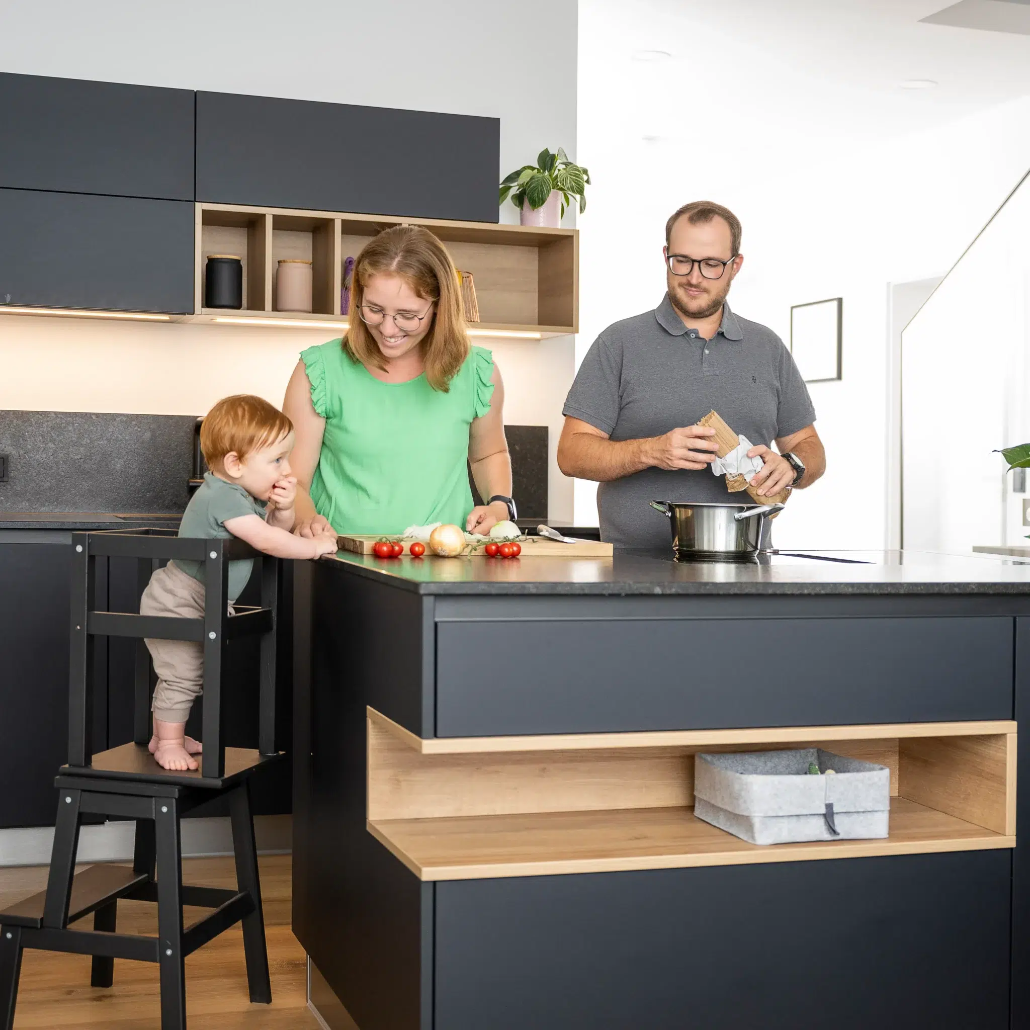Homestory Referenzküche in schwarz mit Familie am kochen